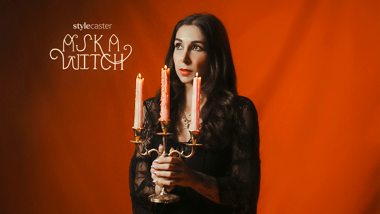 Woman holding a candlestick with flickering flames in front of an orange backdrop